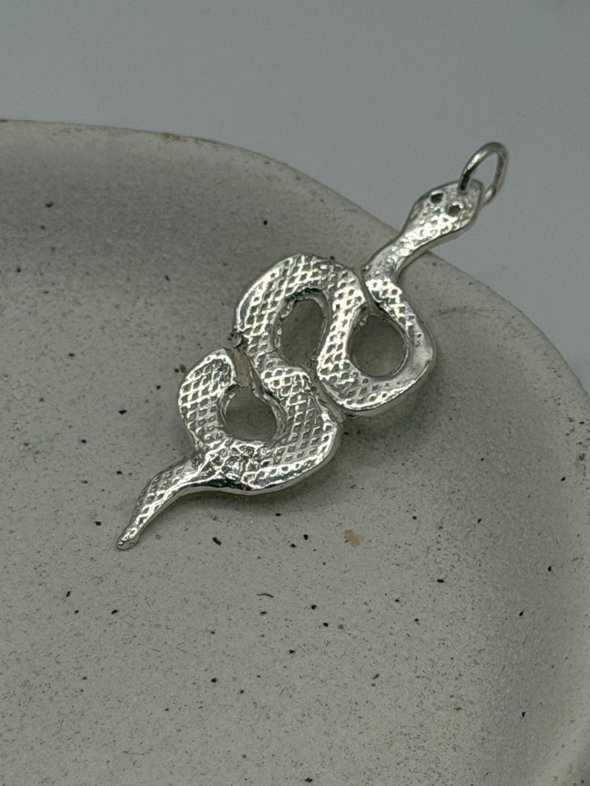 Handmade silver snake charm jewellery from Lincolnshire, featuring a textured fine silver disc with a handstamped Lovers tarot design and beaded detail\.