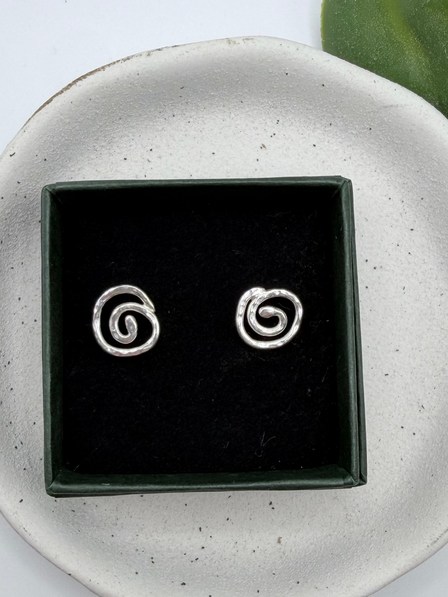 Handmade recycled sterling silver swirl stud earrings with organic spiral designs and a textured polished finish, crafted in small batches by independent Lincolnshire silversmith Wild One Jewellery.