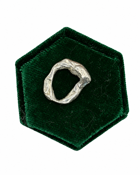 Molten No. 04 handmade recycled sterling silver charm by Wild One Jewellery, featuring a unique organic shape and raw lava-like texture created by melting and quenching silver.