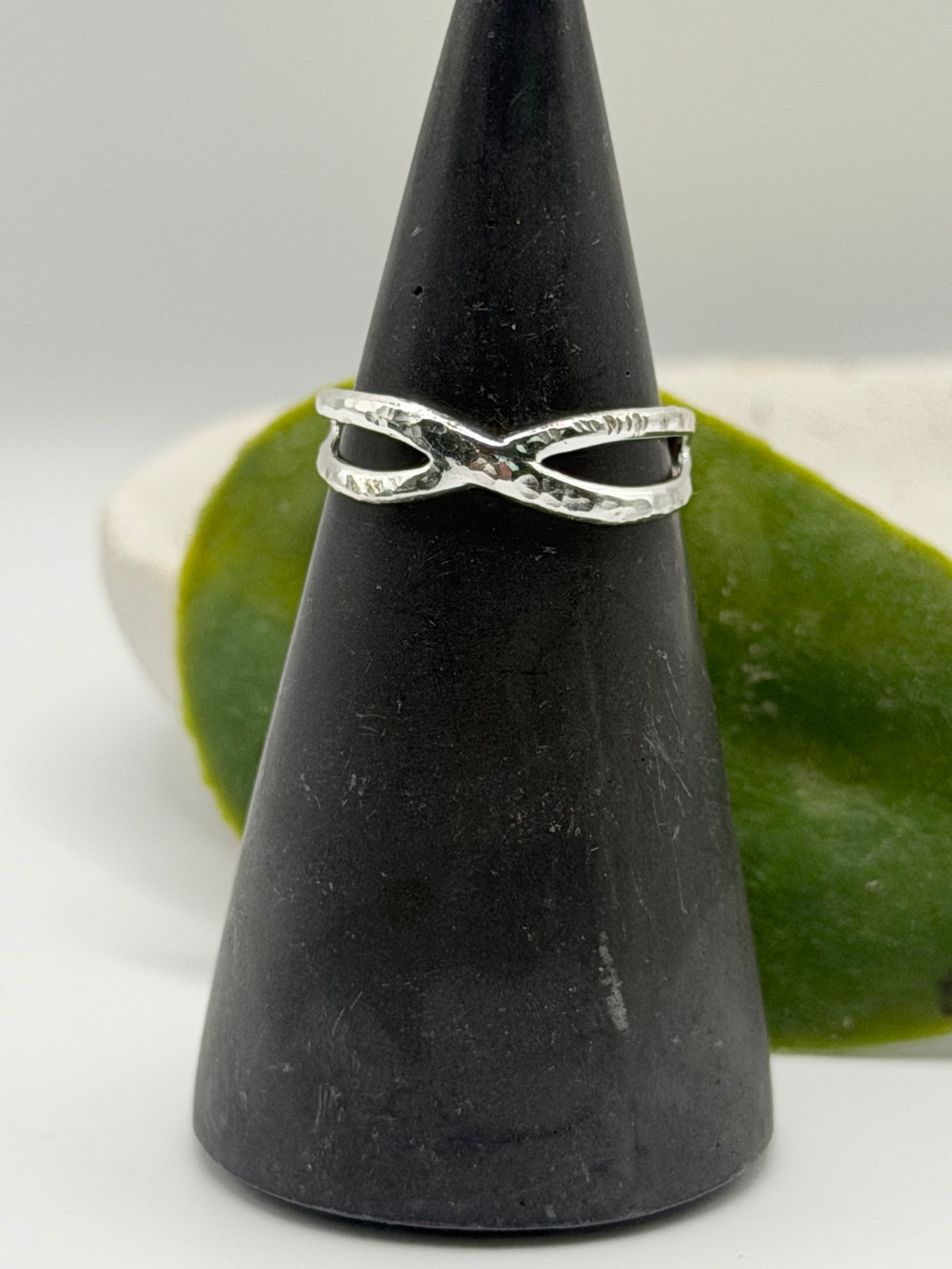 Handmade recycled sterling silver Twist Ring with an organic crossover design and contrasting hammered and linear textures, created in small batches by independent silversmith Wild One Jewellery in Lincolnshire, UK.