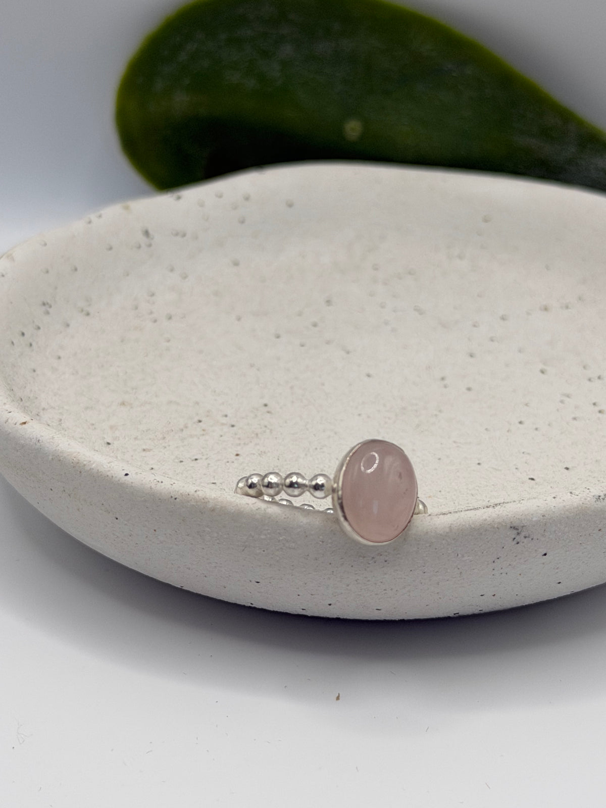 One-of-a-kind rose quartz bobble ring from the Stone + Silver collection by Wild One Jewellery, featuring a pale pink oval cabochon set in a sterling silver band with decorative silver bobble details, displayed in a blue velvet ring box.