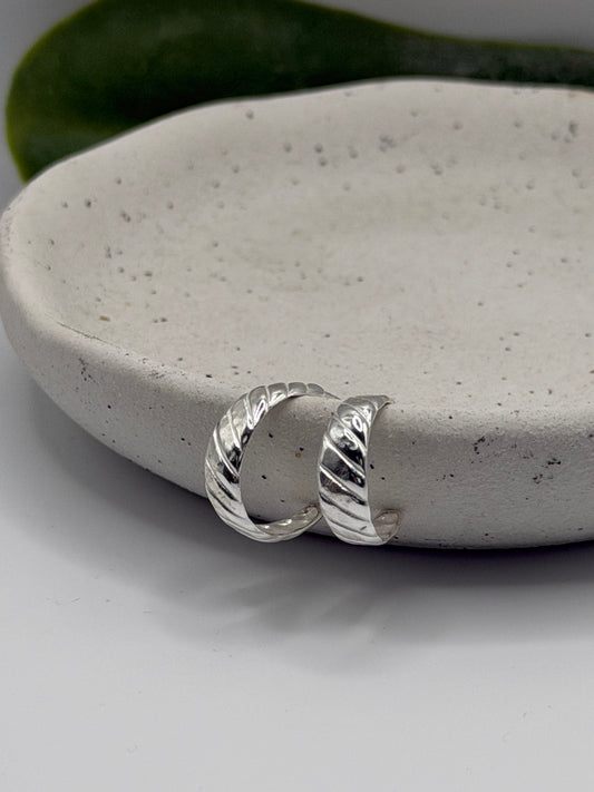 Handmade recycled 925 sterling silver Twust Hoops featuring a curved open design and hammered twist texture, created in small batches by independent silversmith Wild One Jewellery in Lincolnshire, UK.