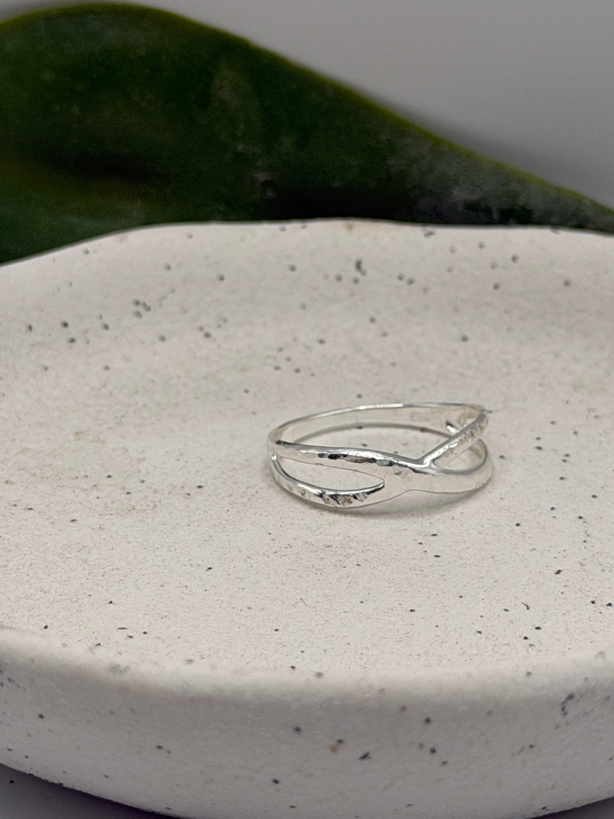 Handmade recycled sterling silver Twist Ring with an organic crossover design and contrasting hammered and linear textures, created in small batches by independent silversmith Wild One Jewellery in Lincolnshire, UK.