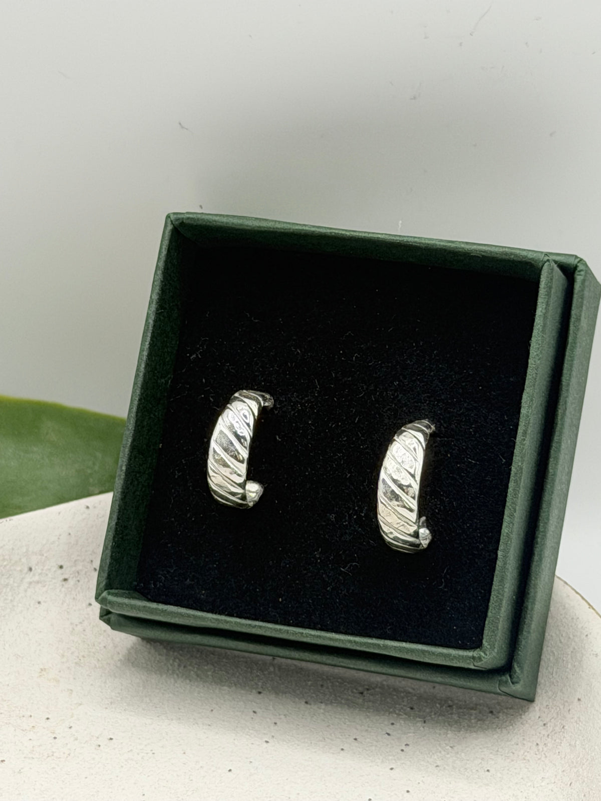 Pair of handcrafted recycled sterling silver Twist Hoops with diagonal textured detailing.